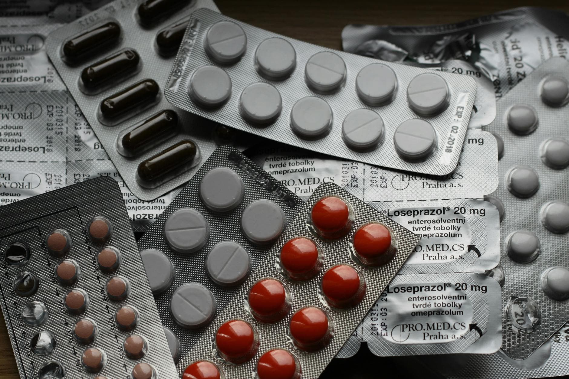 Mehrere teils entleerte Blisterpackungen mit weißen, braunen und roten Tabletten/Kapseln, darunter "Loseprazol".